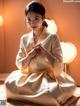 A woman in a white kimono sitting on the floor.