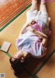 A woman laying on a tatami mat with a book.