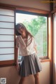 A young woman standing in front of a window.